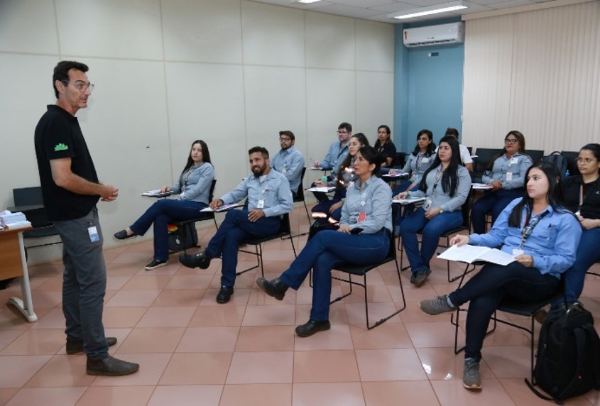 a person standing in front of a group of people sitting in chairs