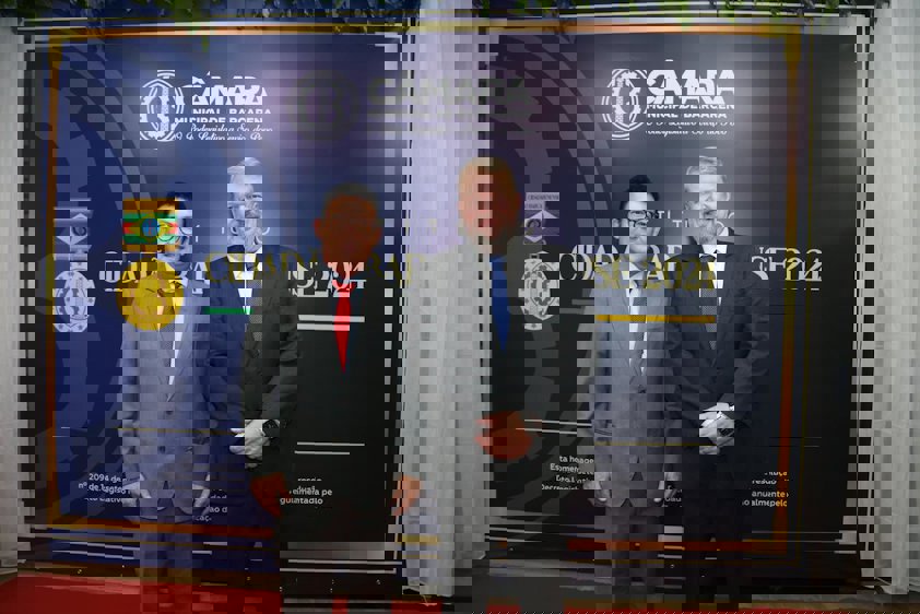 a couple of men standing in front of a sign