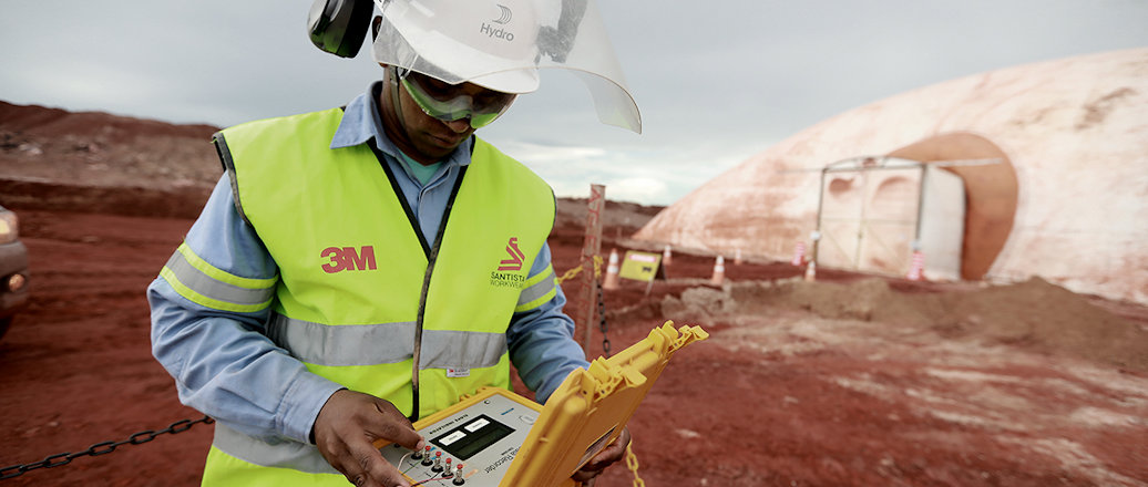 a man wearing a hard hat and holding a tablet