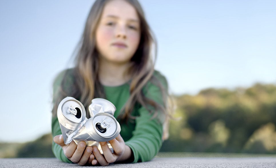 girl holding aluminium cans