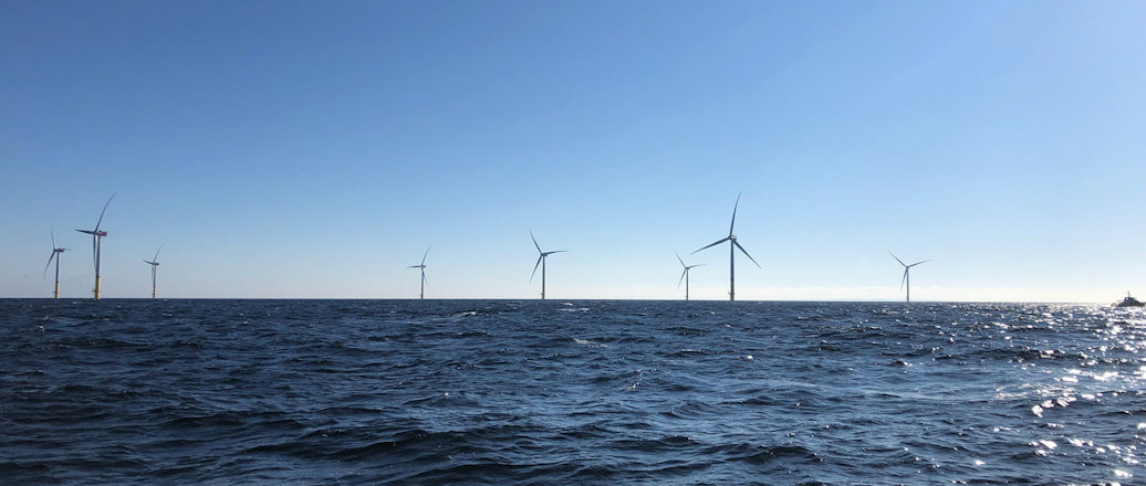 a group of wind turbines in the water