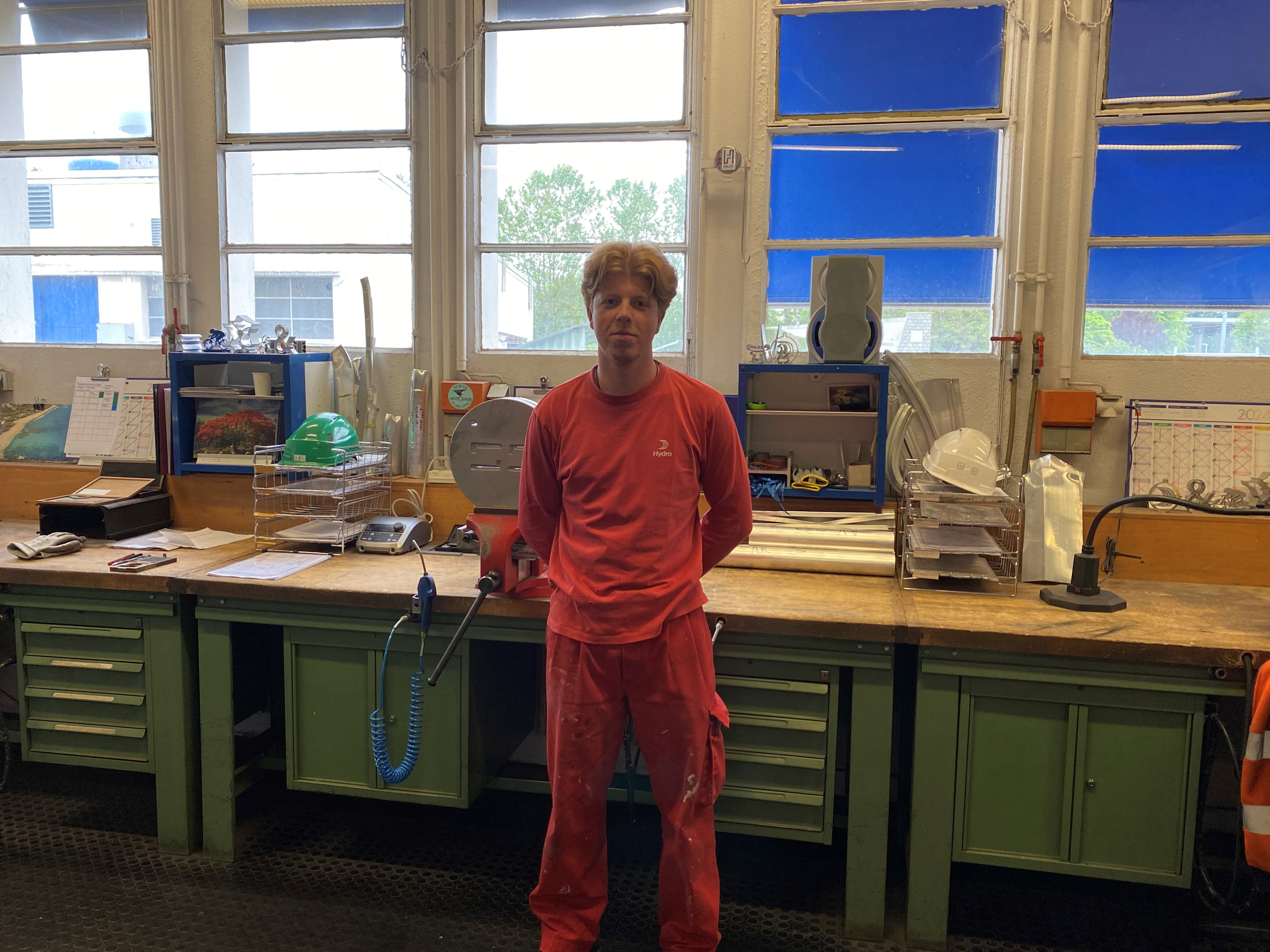 a man standing in front of a desk with a computer on it