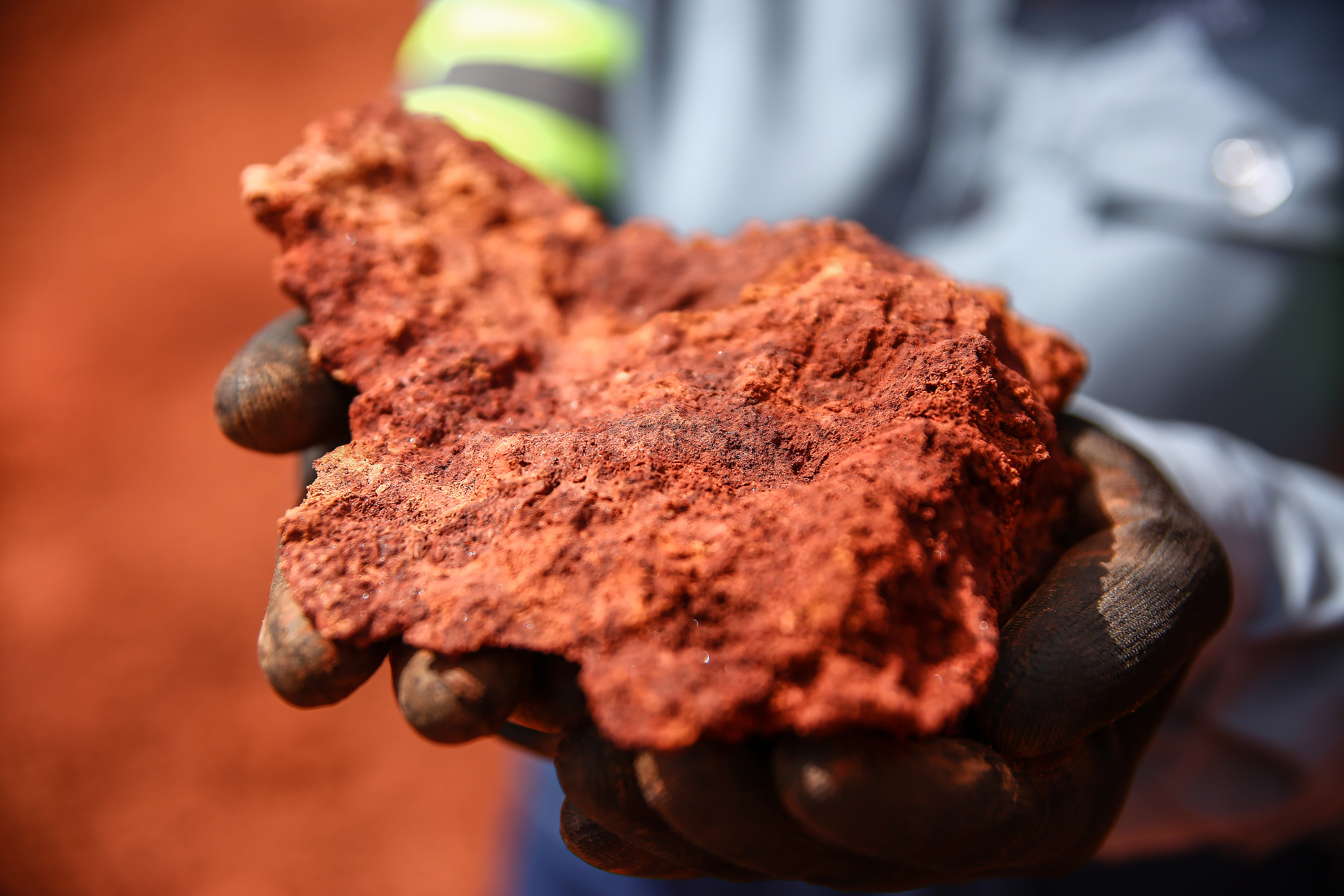 a person holding a piece of red rock