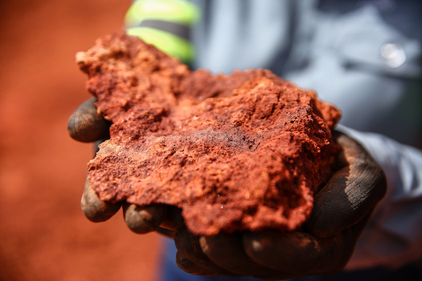 a person holding a piece of red rock