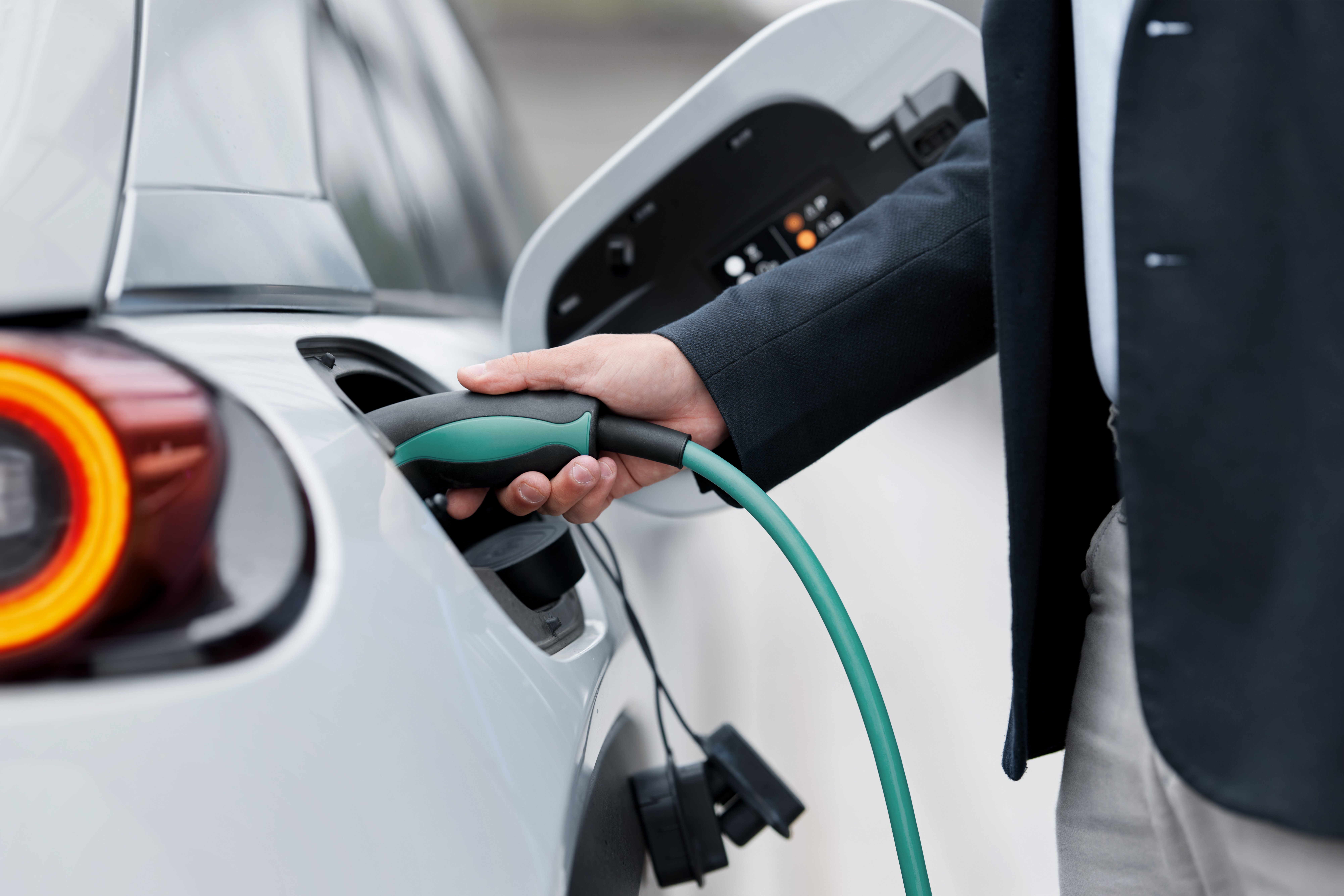 a person charging an electric vehicle