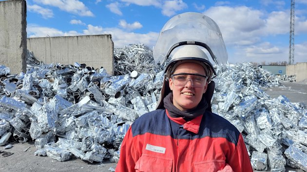 a man wearing a helmet and standing in a pile of garbage