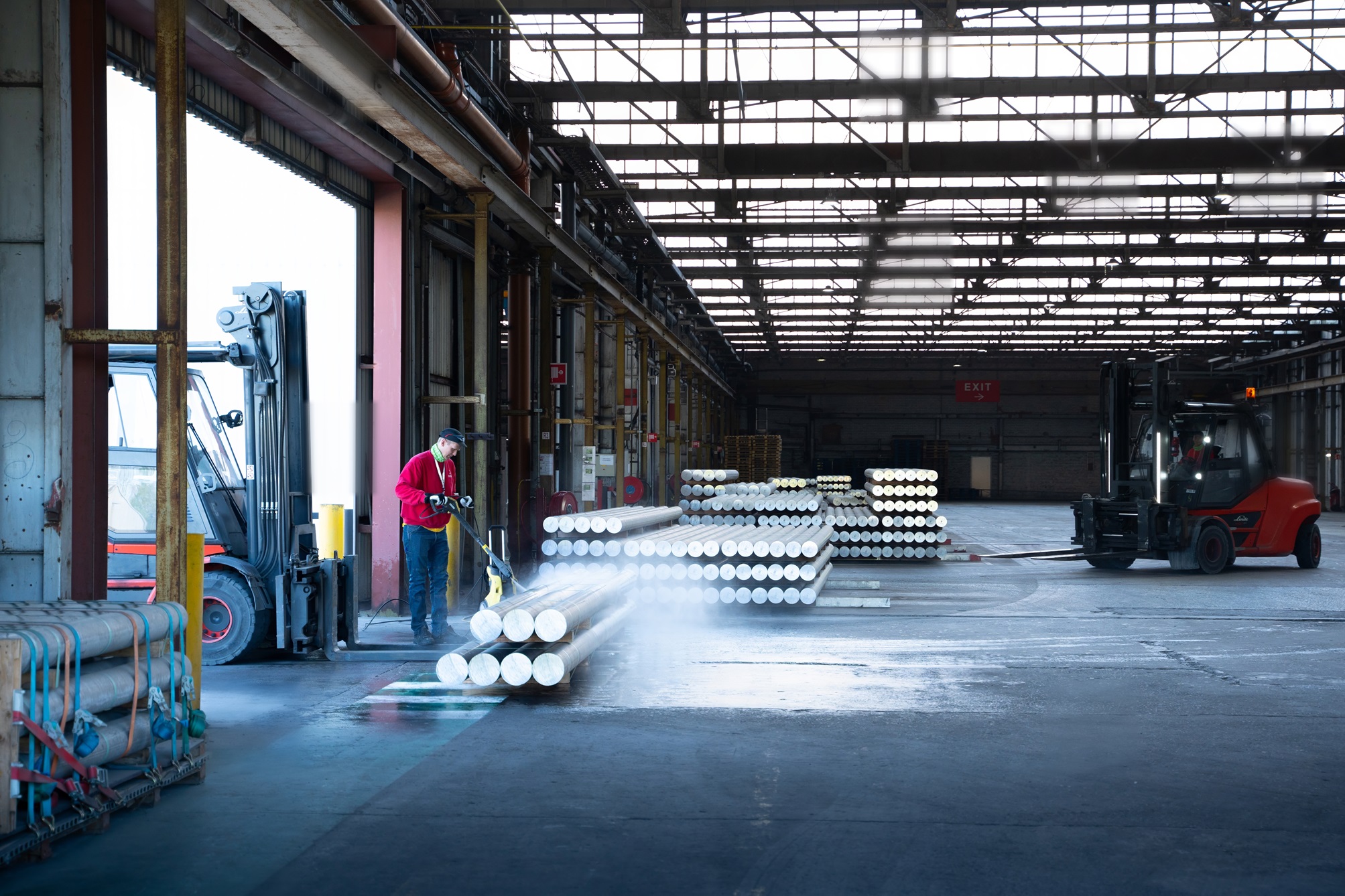 a man holding a forklift and stacking white round objects