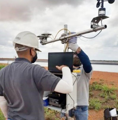 A technical team works with a weather and solar radiation monitoring station.