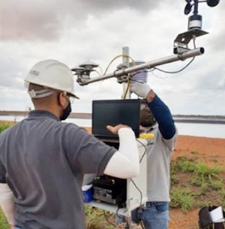 A technical team works with a weather and solar radiation monitoring station.