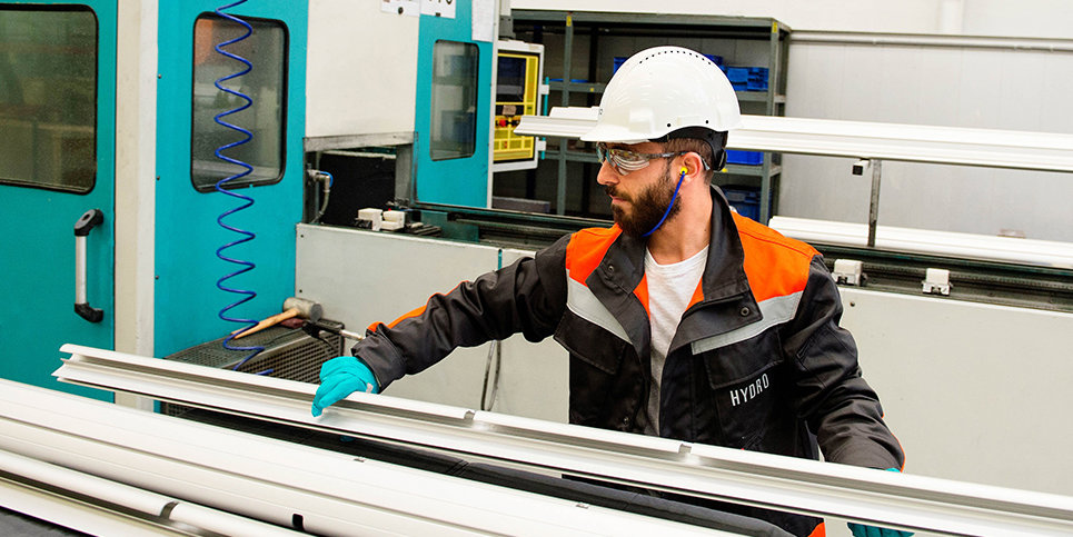 A Hydro employee handling  mechanical treated aluminium profiles