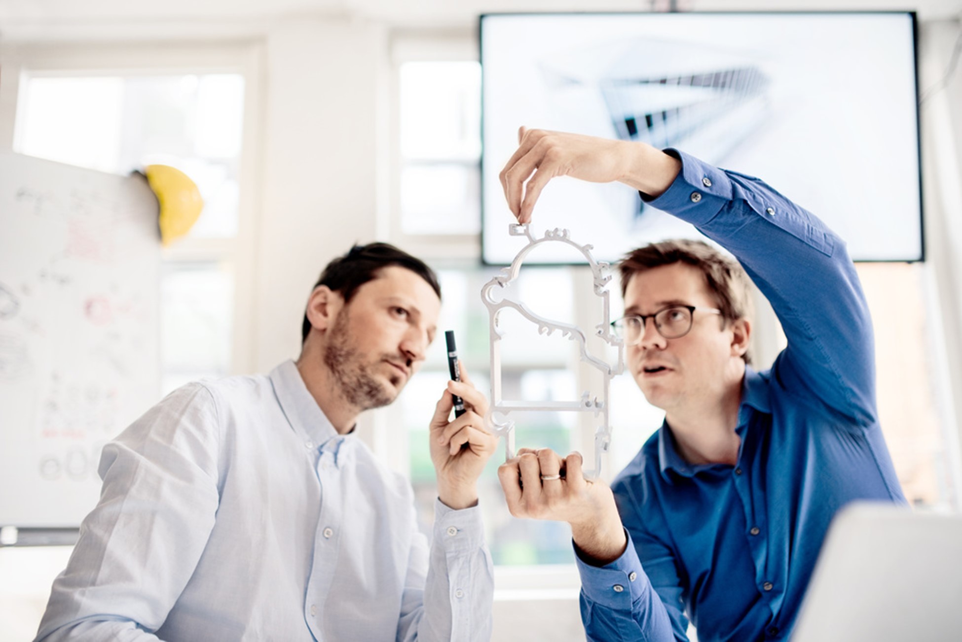 Two men viewing an extruded aluminium profile