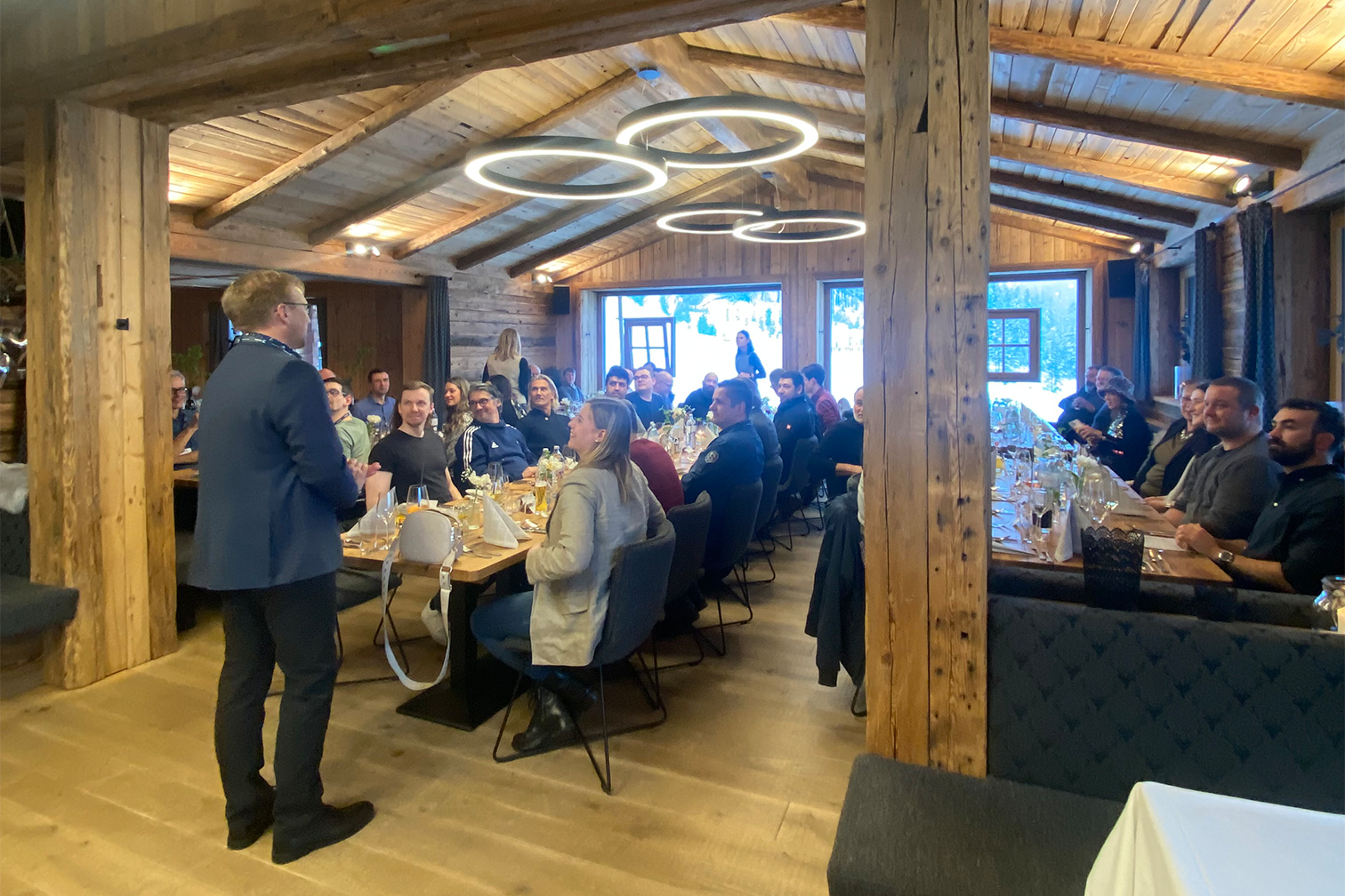 a person standing in front of a group of people sitting at tables