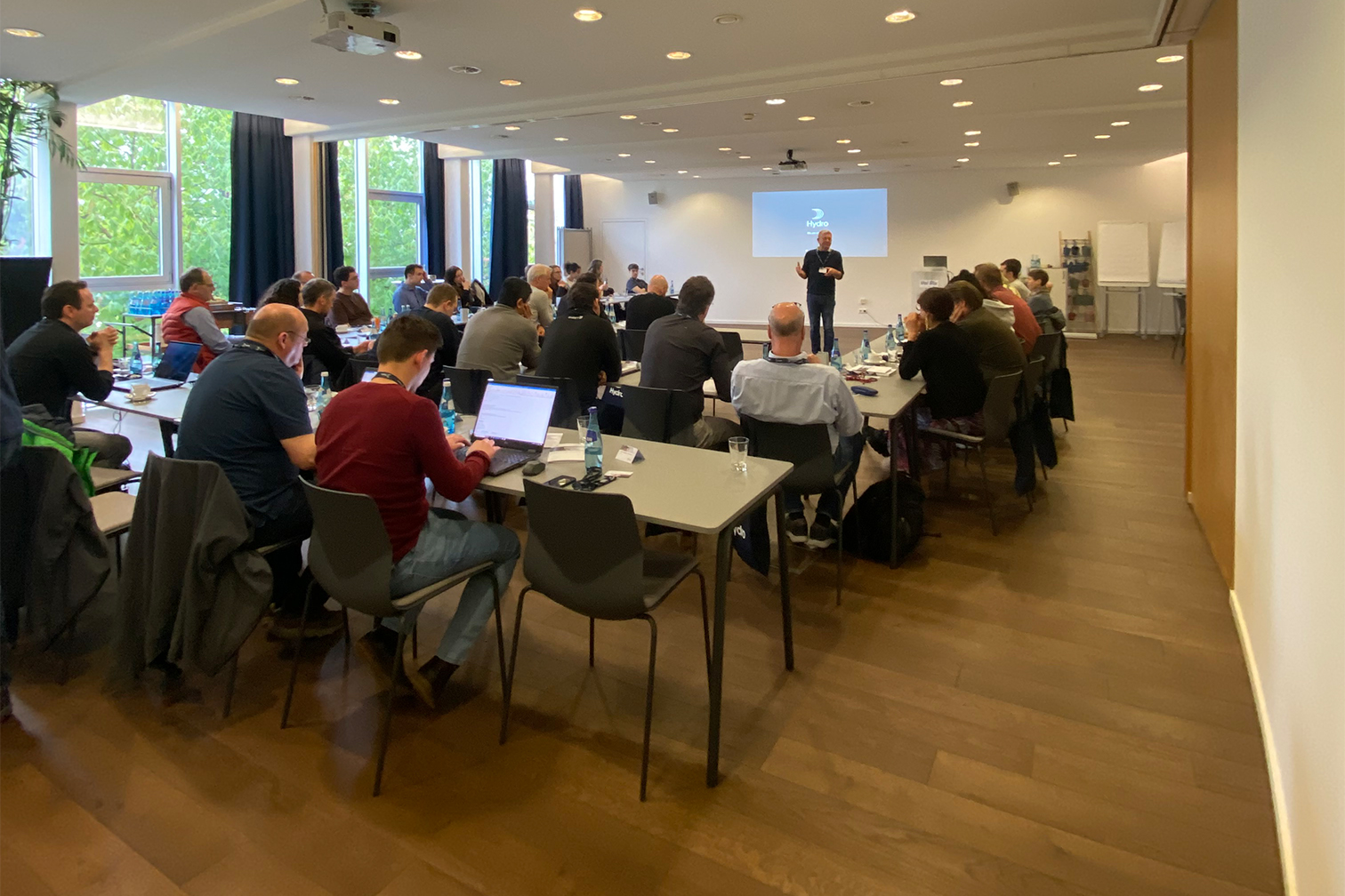 a group of people sitting in a room with laptops
