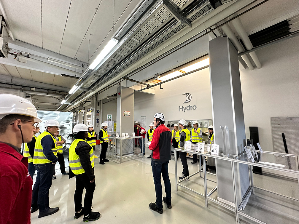 a group of people in hardhats in a factory