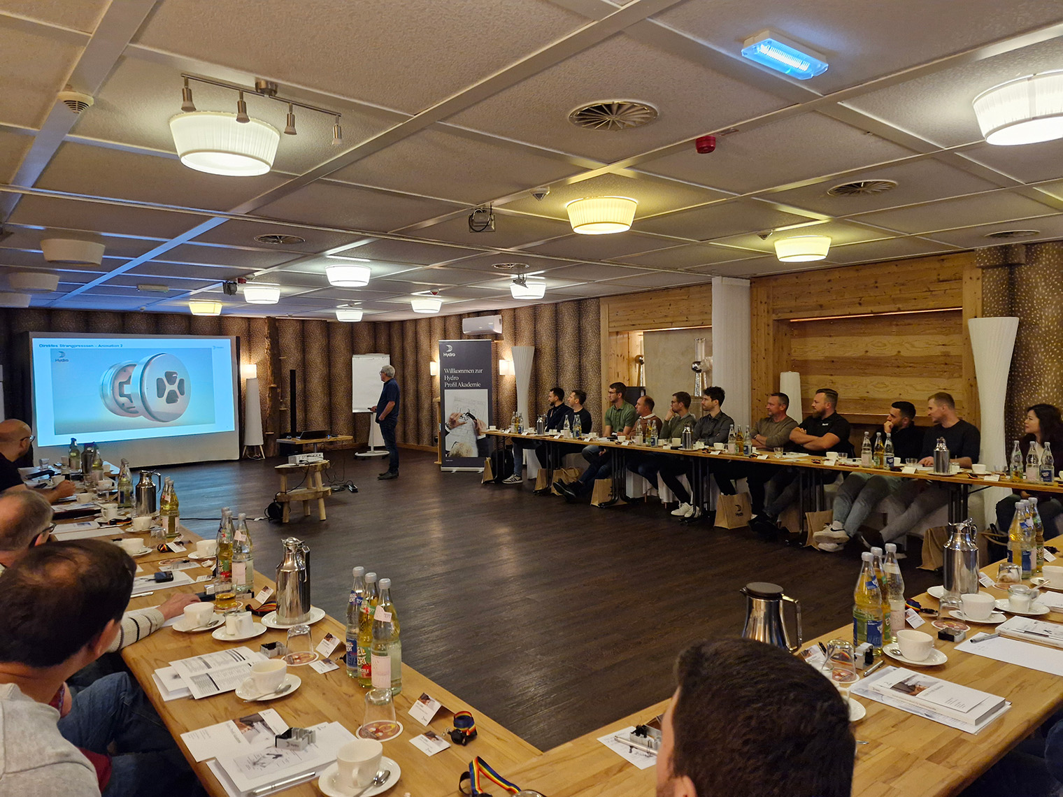 a group of people sitting at tables in a conference room