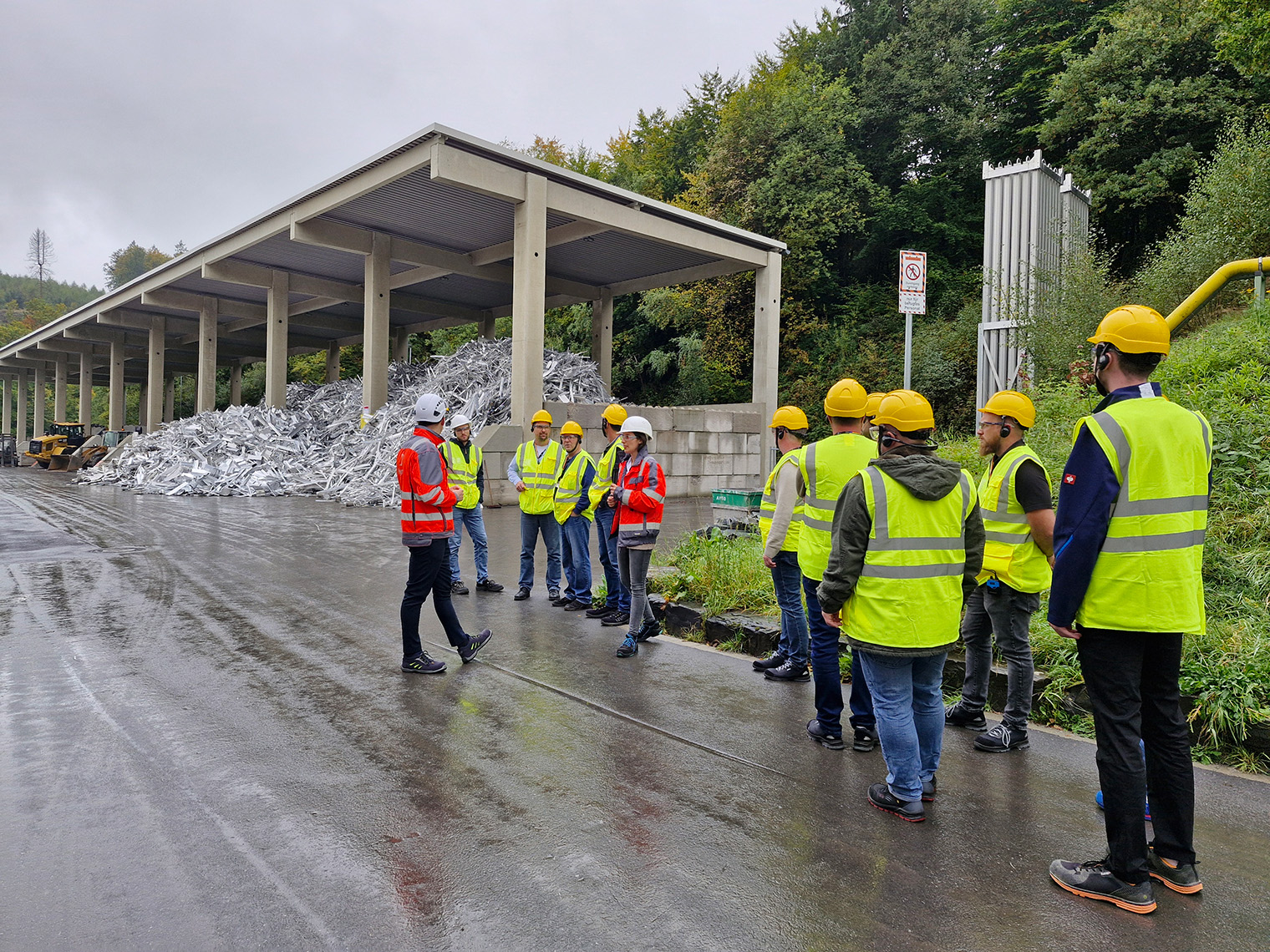 a group of workers in yellow vests standing in a road