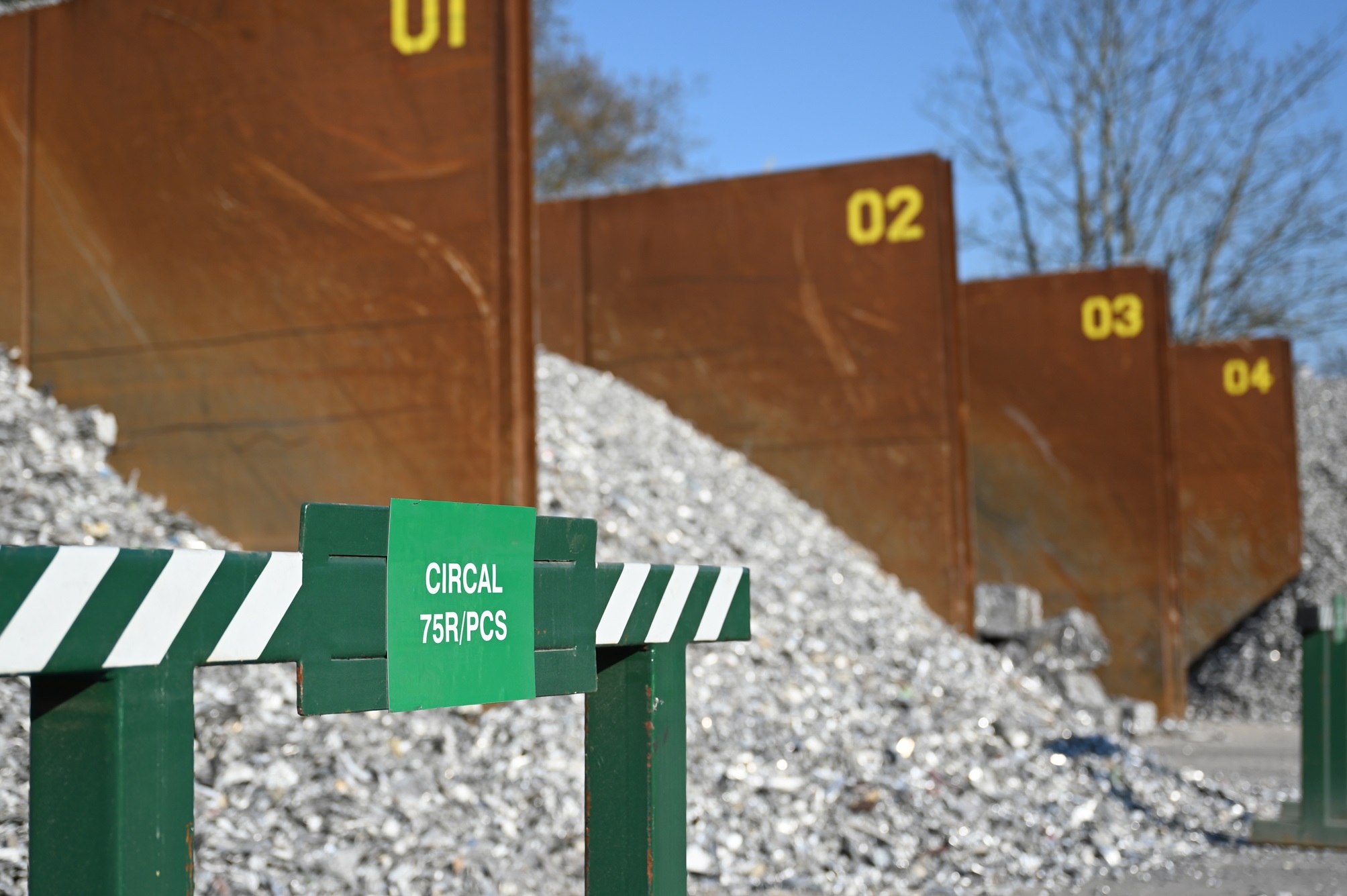 a green sign with white text on it next to a pile of metal