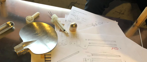 a table with a lamp and a paper with a pen and a pencil