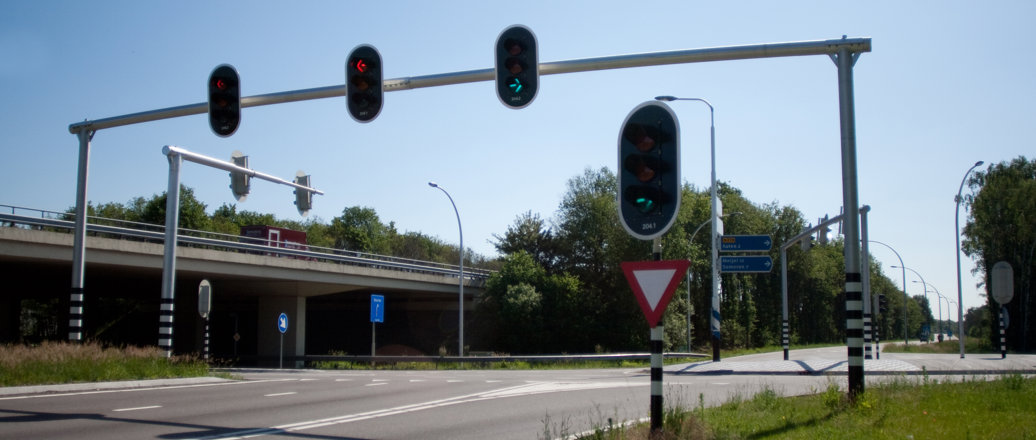 an intersection. traffic lights hanging on a pole across the road