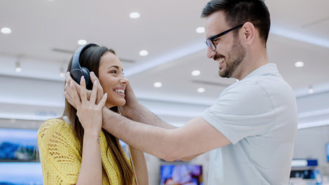 Young couple testing headphones in a tech store