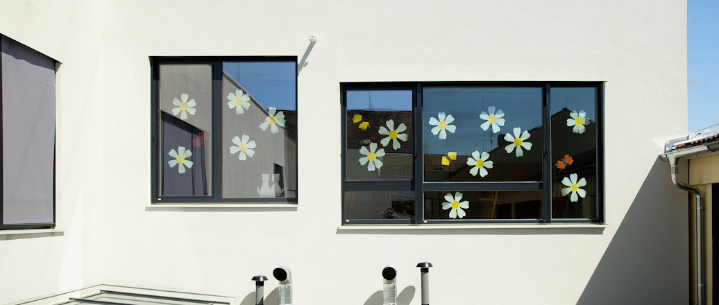 exterior windows, decorated with paper flowers, above a roof