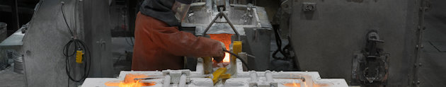 Mann, der mit flüssigem Aluminium in einer Gießerei arbeitet
