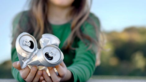 Girl holding crumpled aluminum cans