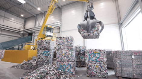 crane moving bales of crushed aluminum cans