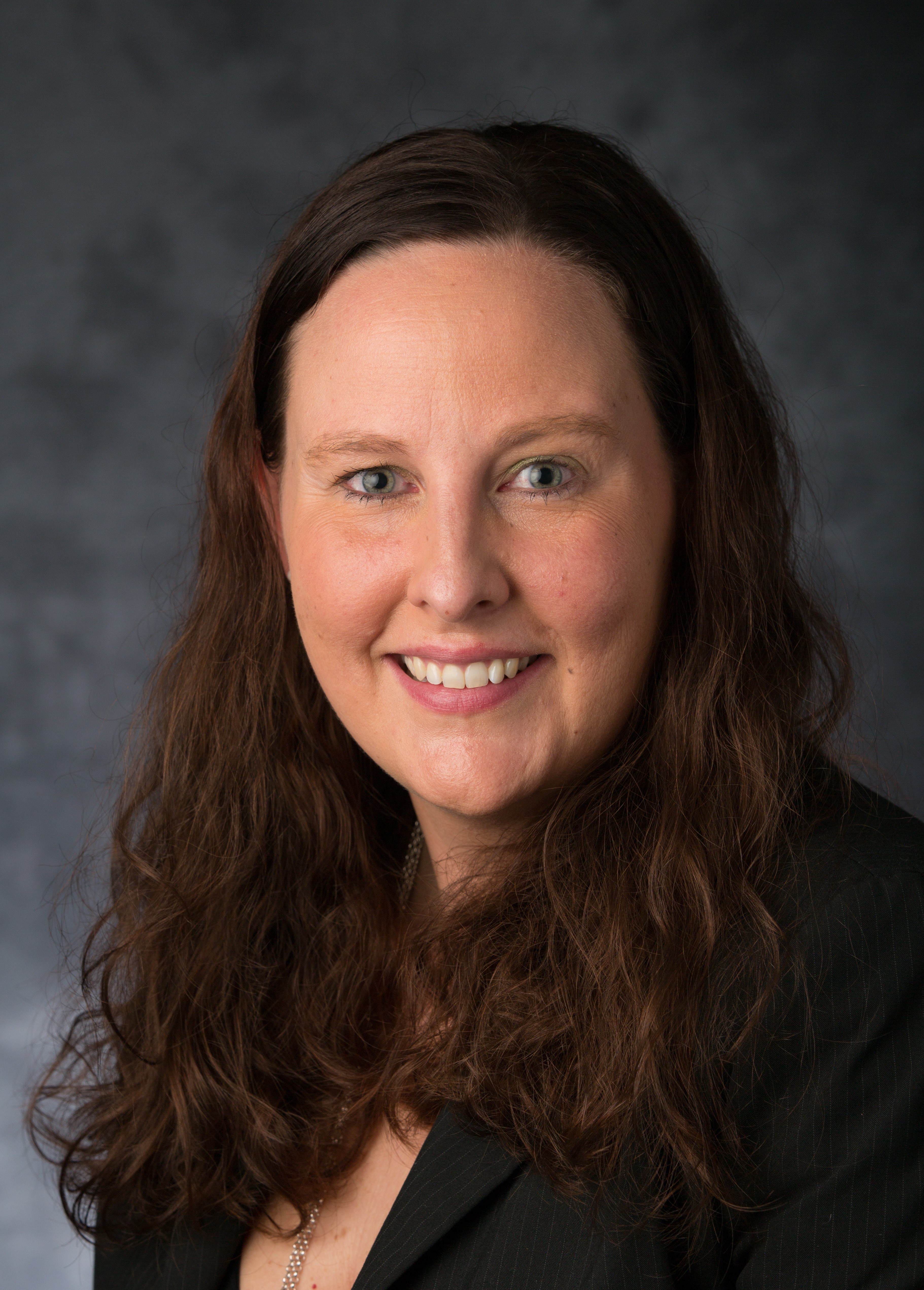 a woman with long brown hair smiling