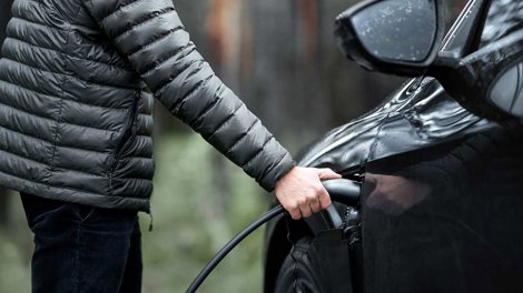 Man charging electric vehicle 