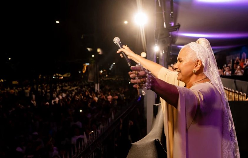a person holding a microphone in front of a large crowd