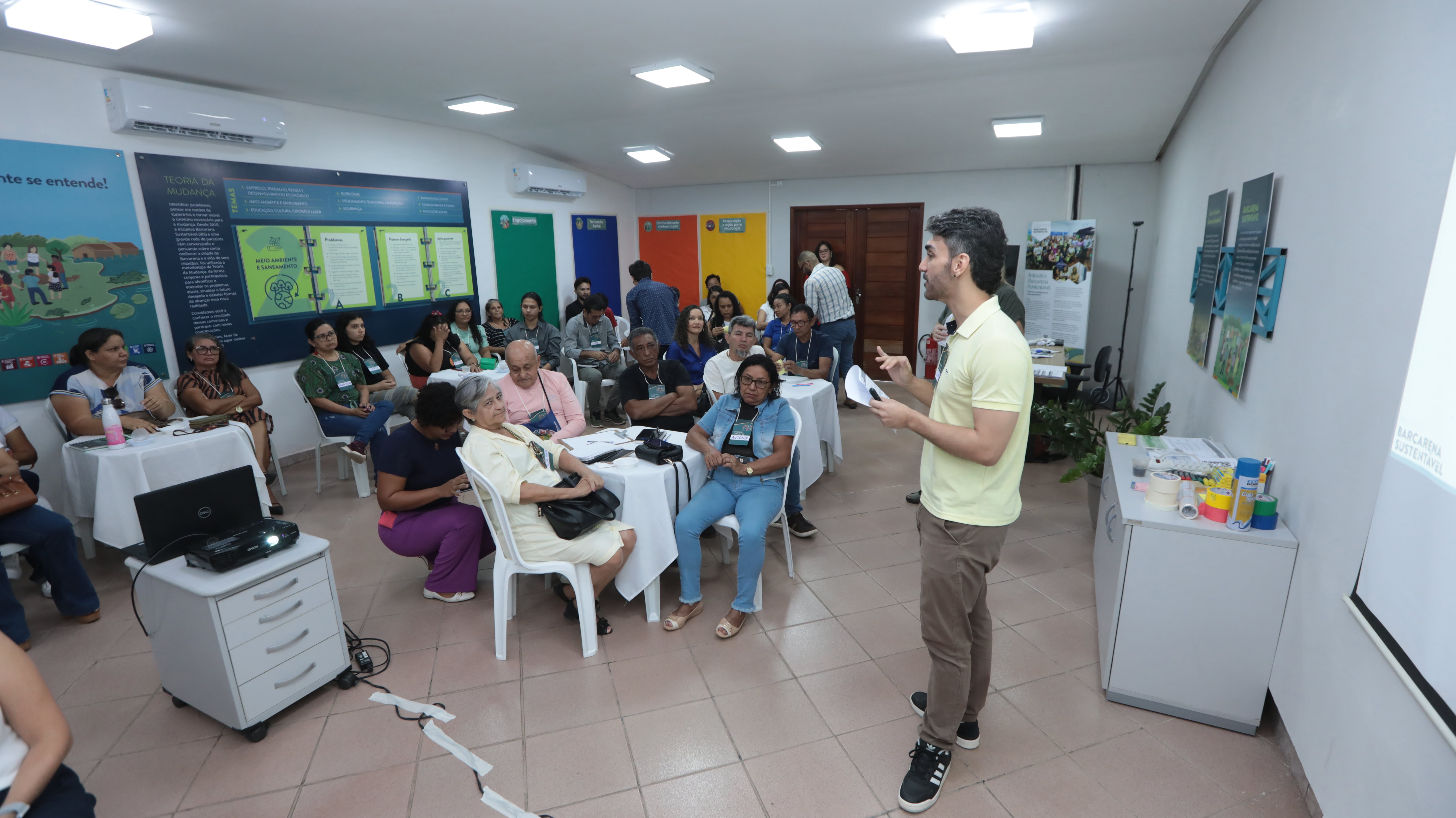 a person standing in front of a group of people sitting in chairs