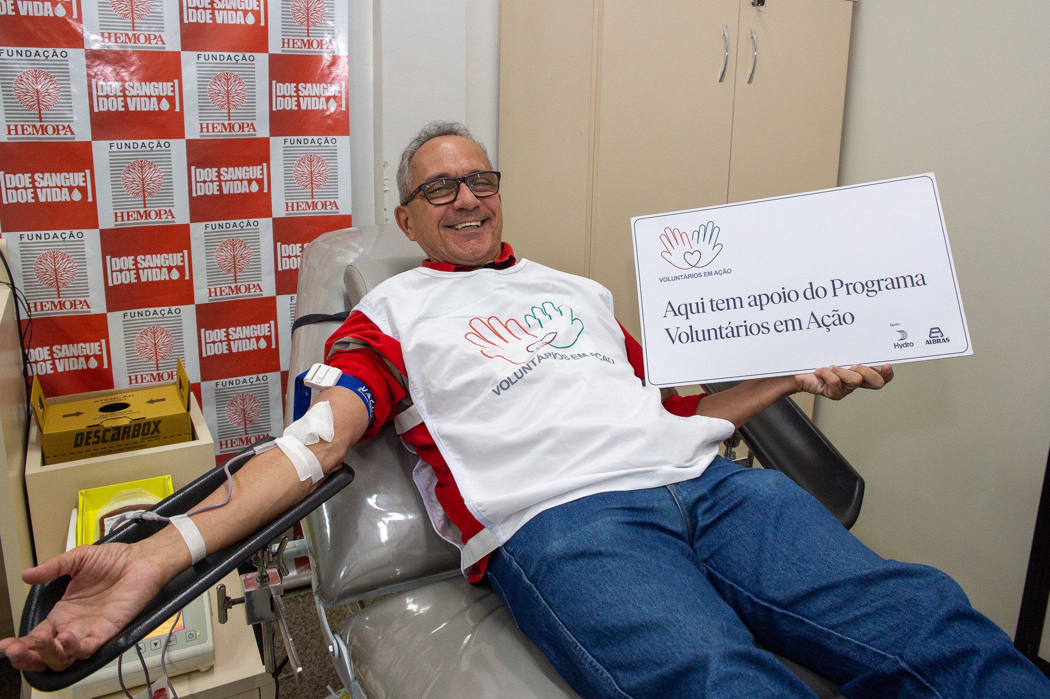 a man sitting in a chair holding a sign