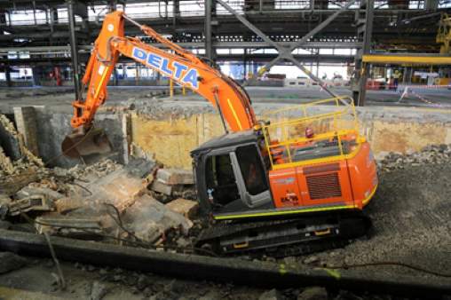 Orange excavator operating inside a building
