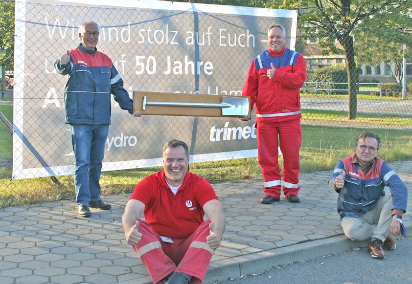 Vier Männer vor einem Banner, das Hydro Hamburg feiert