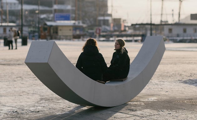 two people sitting on a large white sign