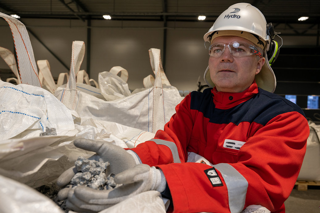 a man wearing a hard hat and protective gear holding a pile of plastic bags
