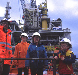 a group of people wearing hardhats and standing on a boat