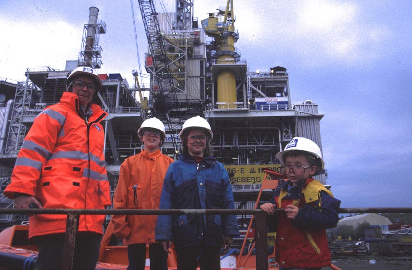 a group of people wearing hardhats and standing on a boat