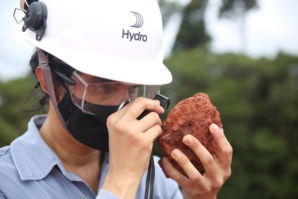 a person wearing a helmet and holding a piece of bauxite