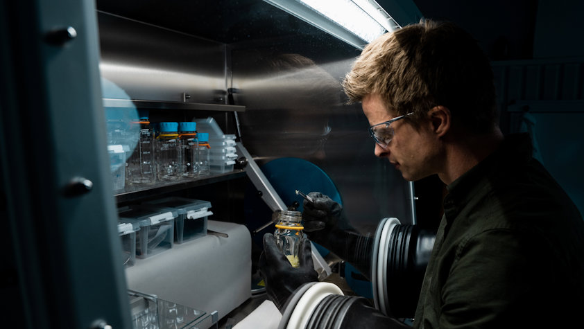 a man in a lab holding a bottle