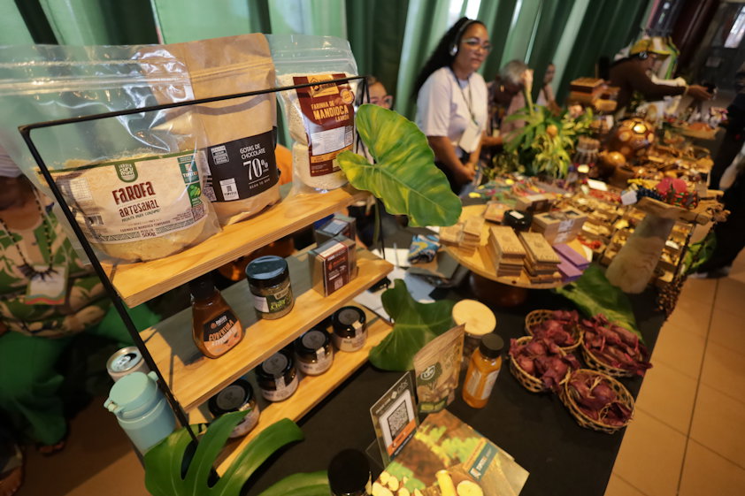 a person standing behind a counter full of food