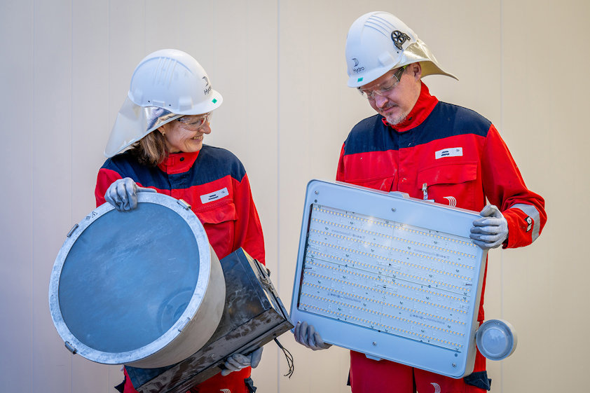 two people wearing hard hats and holding lamps