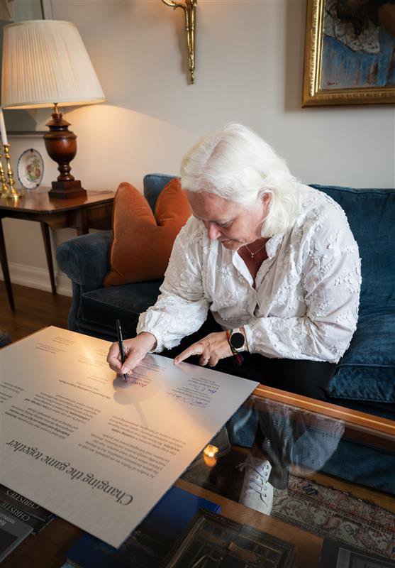 an woman signing a letter