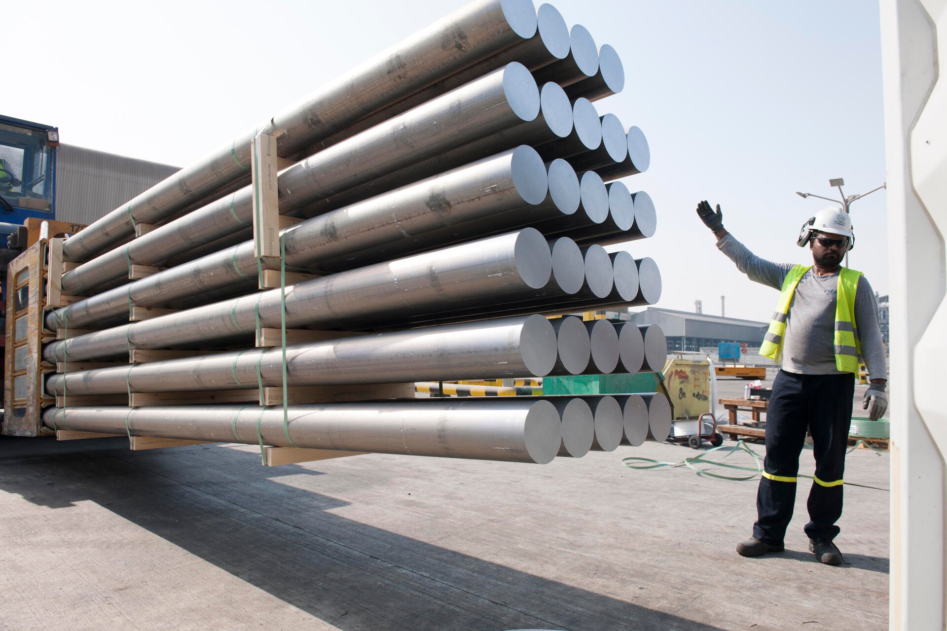 Qatalum employee directing a batch of aluminium billets for transport