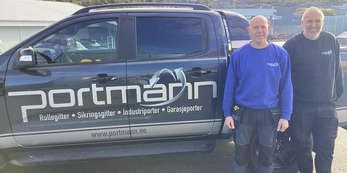 two men standing next to a truck