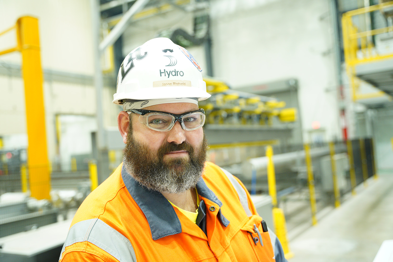 a man wearing a hard hat and orange jacket