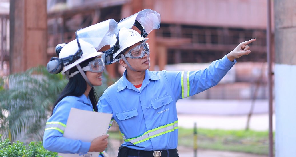 Moça e rapaz, usando uniforme da Hydro, em uma das unidades da empresa em Barcarena