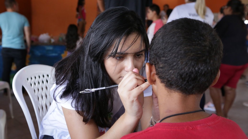Volunteer doing face painting on child