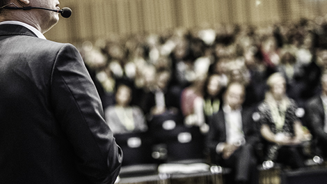 person giving a speach to an auditorium full of people